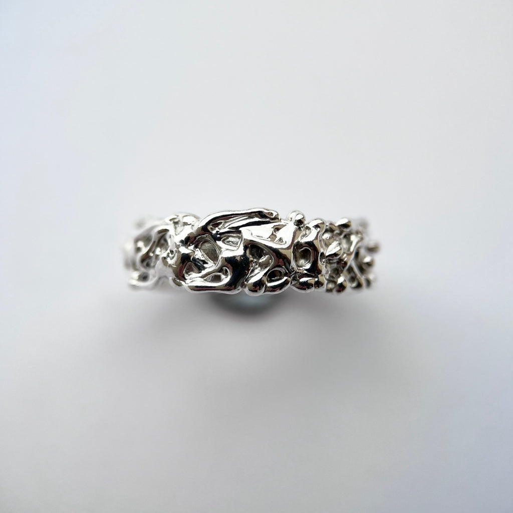 Silver thick band with organic texture on a grey background