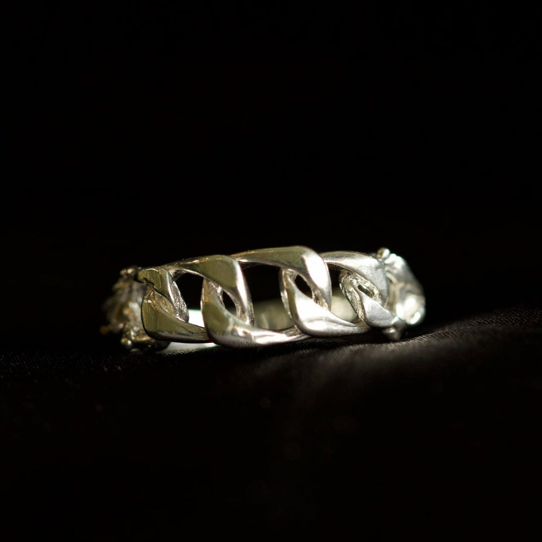 Chain ring with organic texture on black velvety background 