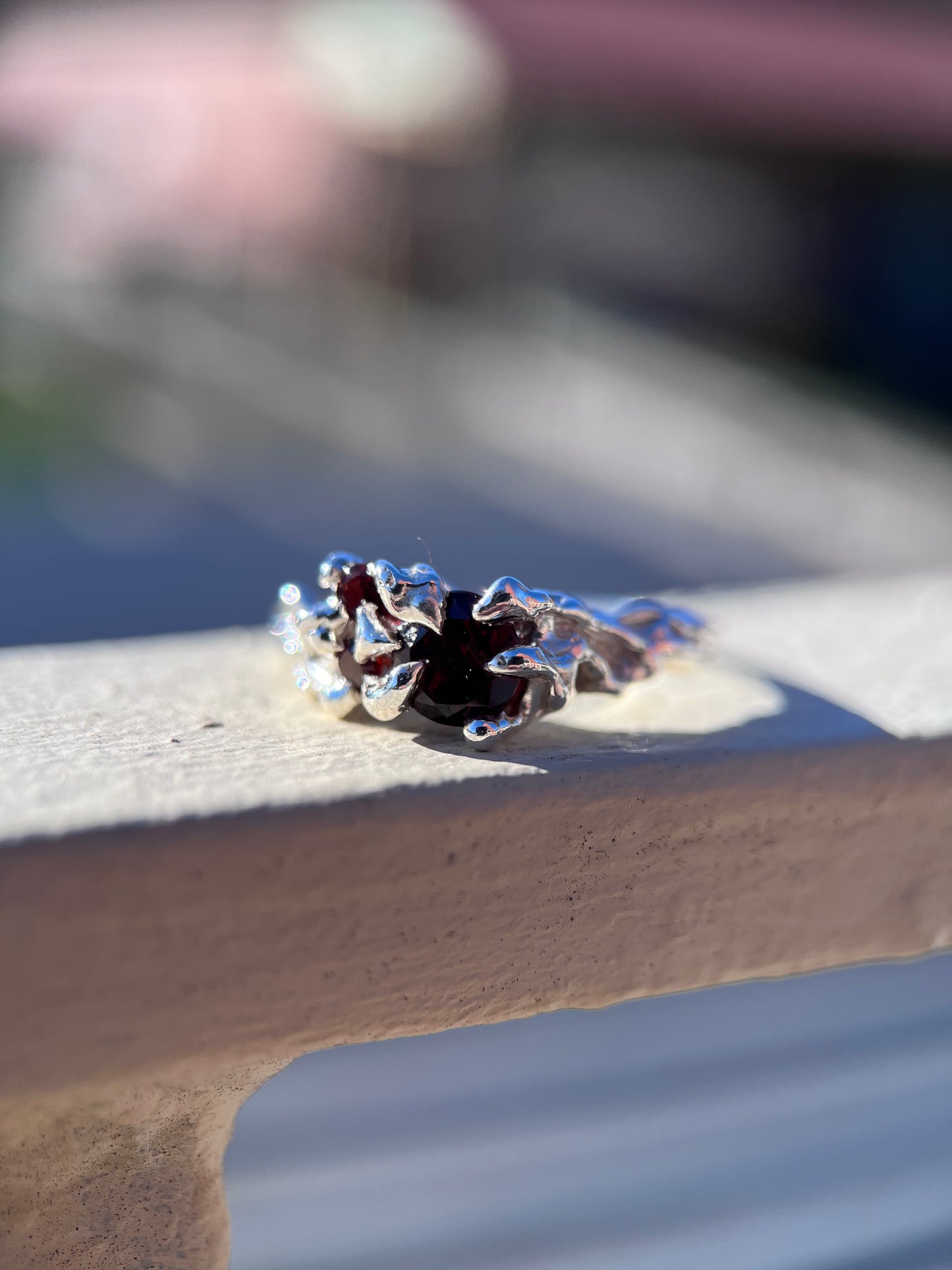 Ethereal silver ring with three wine red Garnets and a vine like texture on the ring face