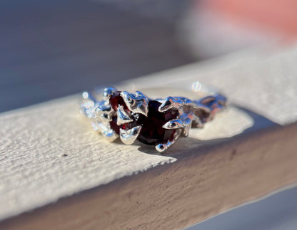 Ethereal silver ring with three wine red Garnets and a vine like texture on the ring face