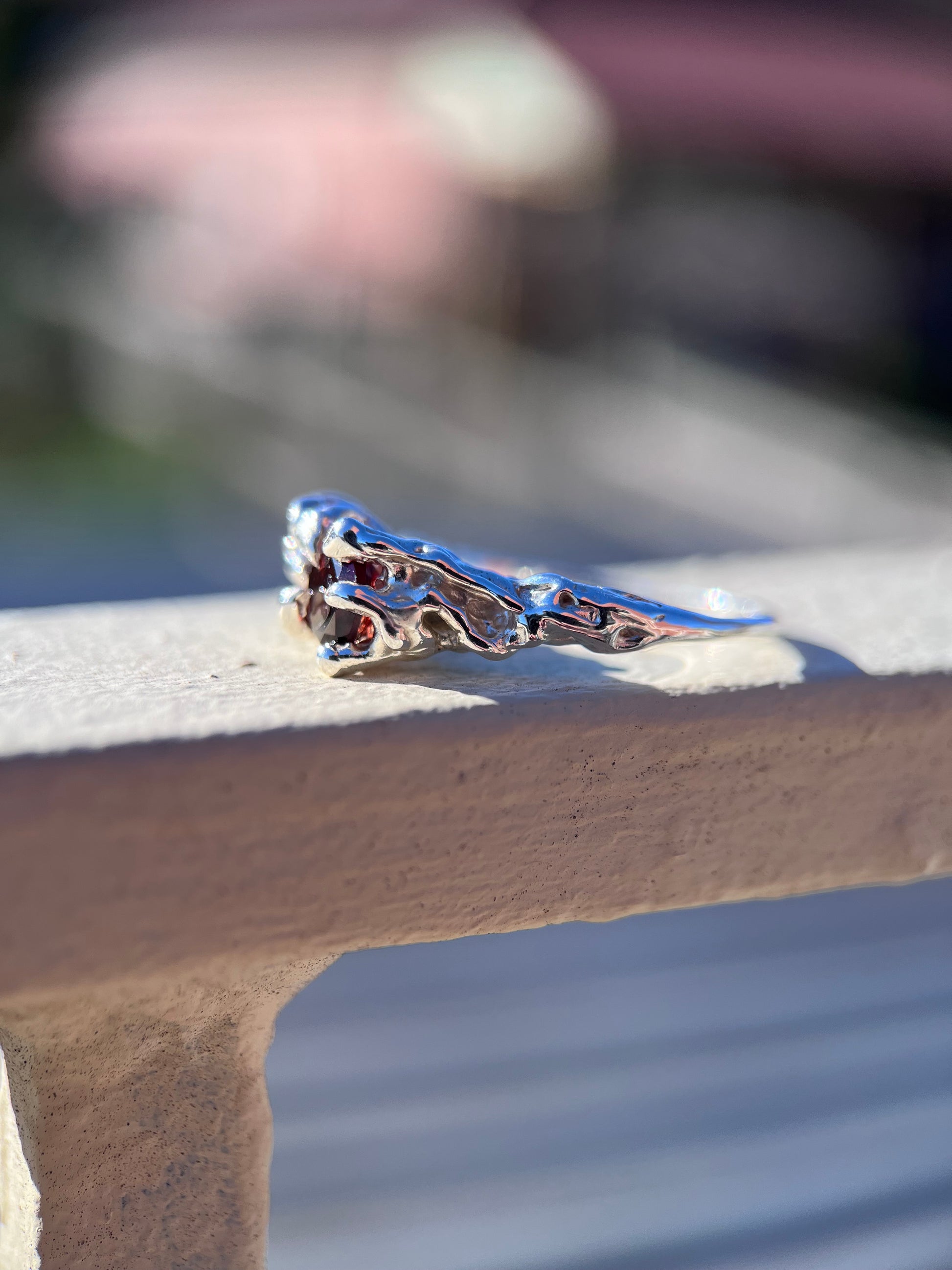 Ethereal silver ring with three wine red Garnets and a vine like texture on the ring face