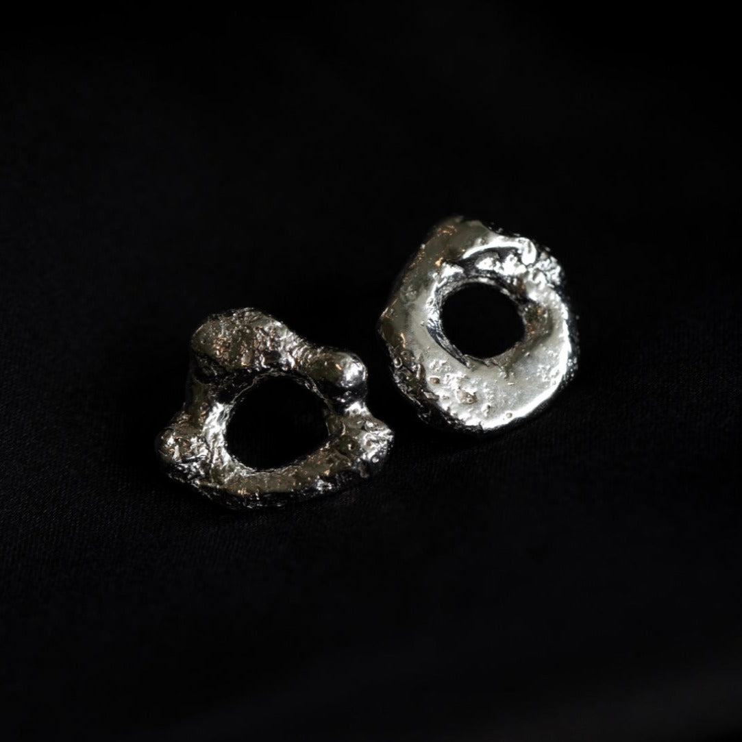 Photo of silver molten loop earrings on a black background