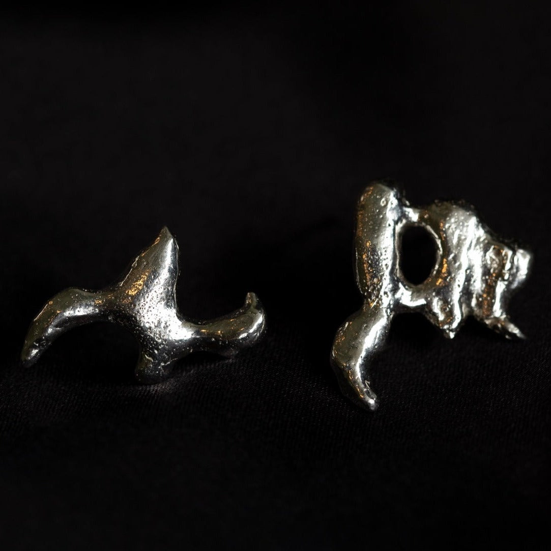  Photo of silver molten asymmetric earrings on a black background