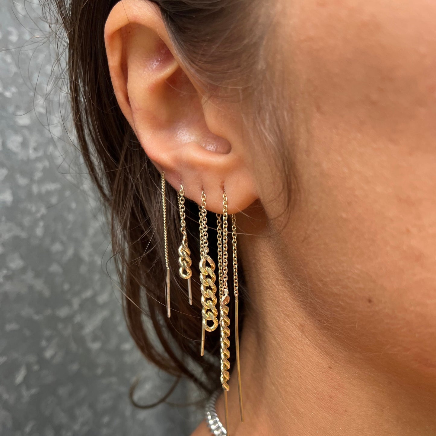 Three Gold chain pull through earrings worn earlobe